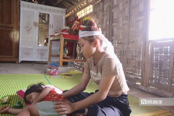 Chị Lệ - người vợ trẻ mất chồng - thất thần ngồi trong căn nhà tranh vách nứa cạnh di ảnh của chồng.