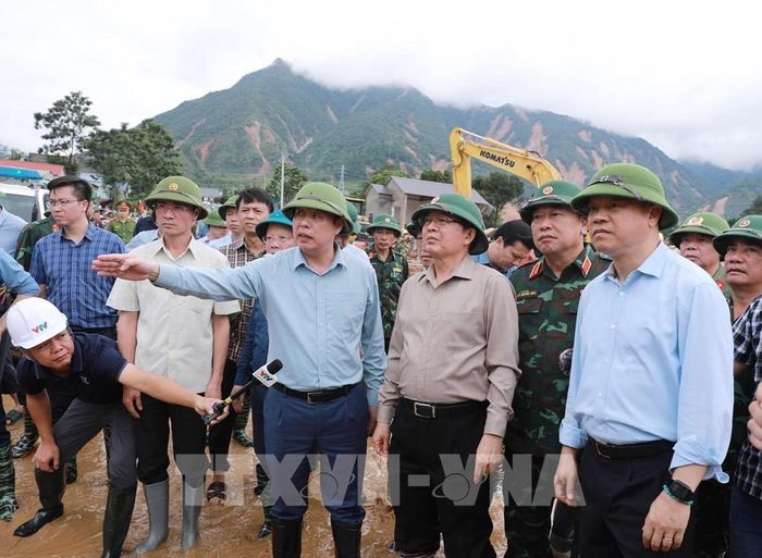 Phó Chủ tịch UBND tỉnh Lai Châu báo cáo với Phó Thủ tướng Hồ Quốc Dũng về những khu vực bị thiệt hại do lũ dữ tàn phá tại Bản Chít. Ảnh: Quý Trung - TTXVN