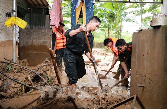 Lực lượng Công an tỉnh Lai Châu hỗ trợ người dân khắc phục. Ảnh: Quý Trung - TTXVN