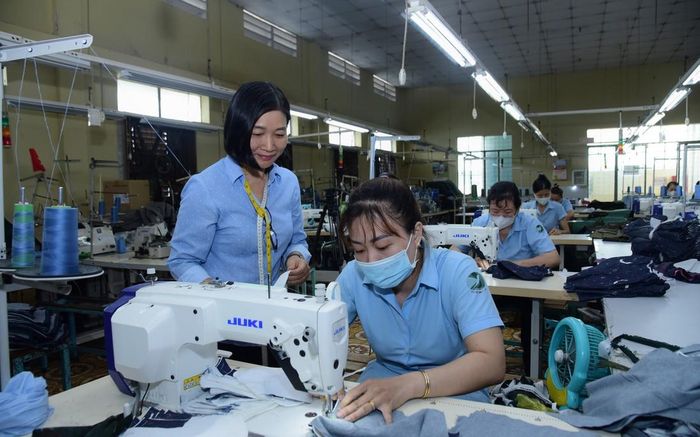 Chị Nguyễn Thị Hưng (bên trái), nhân viên kỹ thuật Công ty cổ phần Dệt may 7 kiểm tra kỹ thuật may của công nhân.