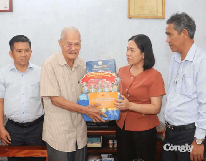Đồng chí Trần Thu Mai trao quà cho ông Lương Duy Thoại.