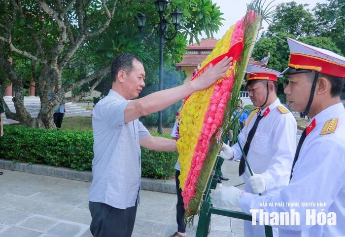 Phó Bí thư Tỉnh ủy Trịnh Tuấn Sinh chỉnh trang vòng hoa trước khi viếng các Anh hùng liệt sĩ.