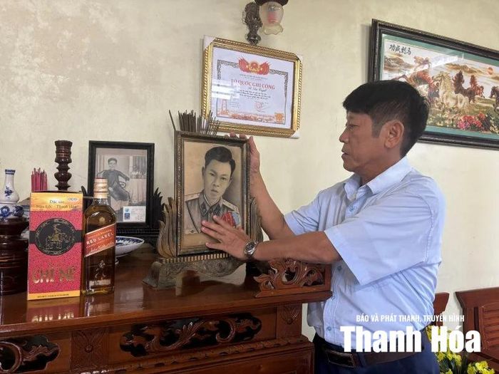 Ông Lê Văn Bút bên di ảnh của cha mình.