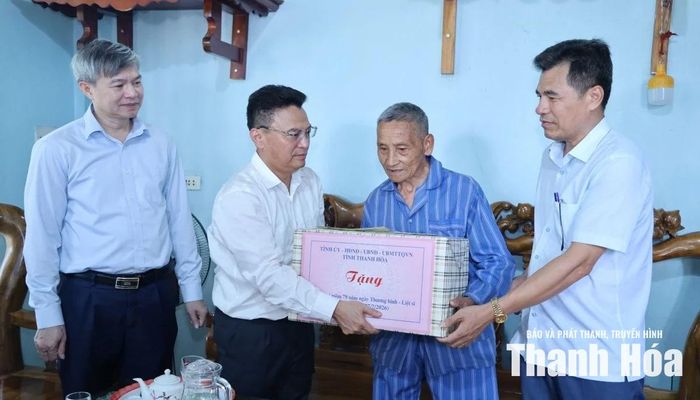 Trưởng Ban Quản lý KKT Nghi Sơn và các khu công nghiệp tỉnh Trịnh Huy Triều tặng quà cho nạn nhân nhiễm chất độc da cam Hà Công Thành.