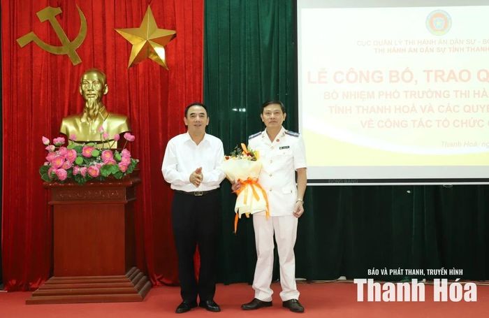 Lãnh đạo Tòa án Nhân dân tỉnh Nguyễn Văn Khuyên tặng hoa chúc mừng tân Phó trưởng Thi hành án dân sự tỉnh Trần Anh Tuấn.