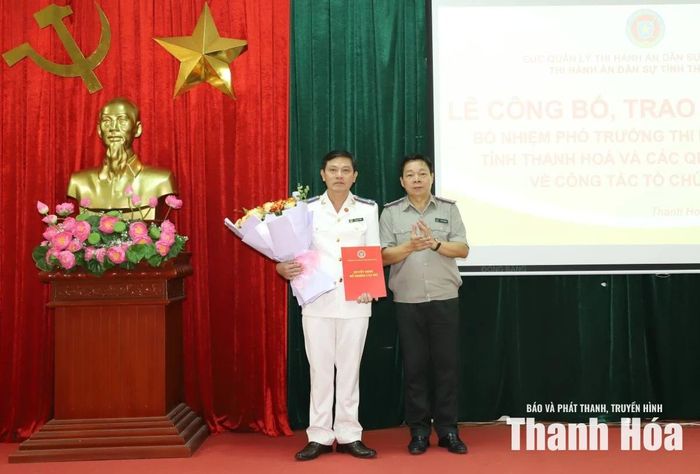 Trưởng Thi hành án dân sự tỉnh Trần Văn Dũng trao quyết định và tặng hoa chúc mừng đồng chí Trần Anh Tuấn.