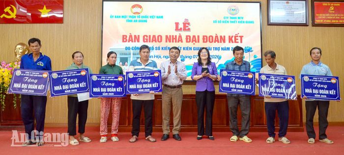 Phó Chủ tịch Ủy ban MTTQ Việt Nam tỉnh An Giang Hà Minh Trang (thứ tư, từ phải qua) và Chủ tịch HĐND xã Tân Hội Lâm Văn Út trao bảng tượng trưng bàn giao nhà đại đoàn kết cho các hộ gia đình.
