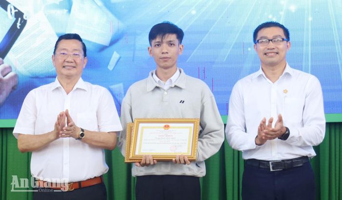 Giám đốc Sở Giáo dục và Đào tạo tỉnh An Giang Trần Quang Bảo (bìa trái) trao giải nhất cho tác giả Phạm Minh Triết (giữa), giáo viên Trung tâm Giáo dục nghề nghiệp - Giáo dục thường xuyên Châu Thành (xã Châu Thành).