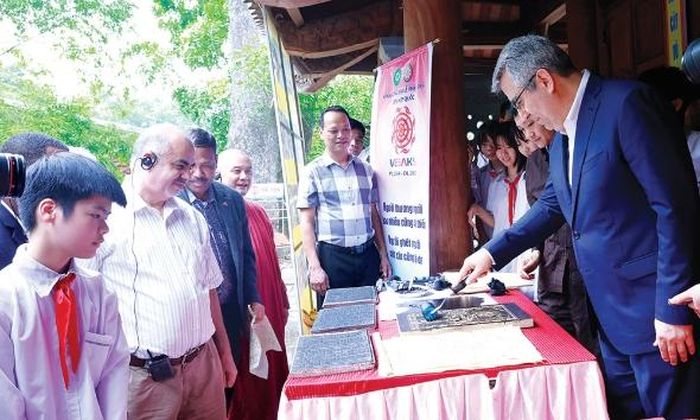 Du khách nước ngoài trải nghiệm in mộc bản chùa Vĩnh Nghiêm (phường Tân An).
