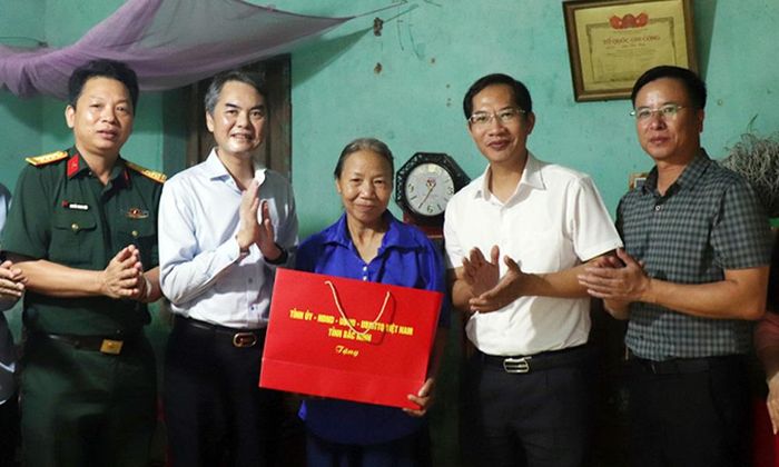 Đồng chí Vũ Minh Hiếu và các đồng chí trong đoàn tặng quà gia đình bà Nguyễn Thị Nguyện, thôn Tân Sơn.