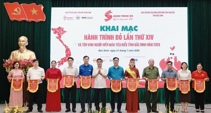 Đồng chí Lê Xuân Lợi trao biểu trưng "Hành trình đỏ" cho các đơn vị đồng hành, hưởng ứng chương trình.