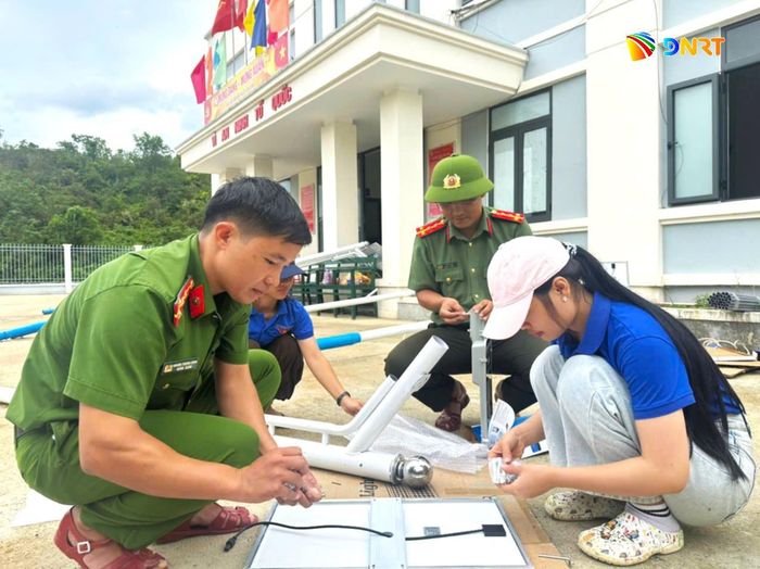 Đoàn viên Công an thành phố Đà Nẵng cùng đoàn viên xã Đắc Pring lắp đặt hệ thống đèn điện tại thôn thôn 56. Ảnh: ANH ĐỨC