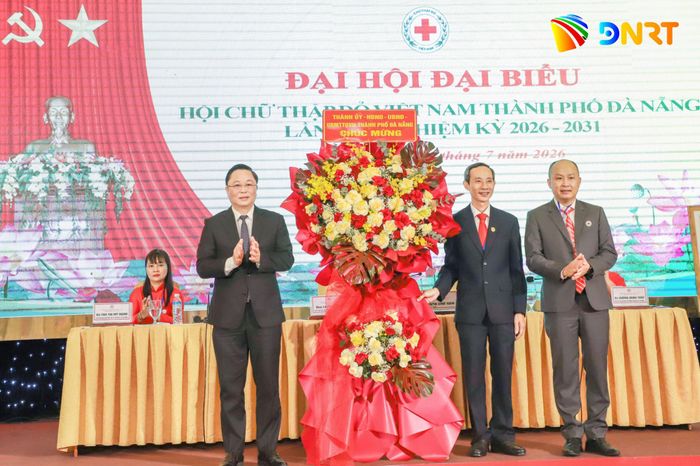 Chủ tịch Ủy ban MTTQ Việt Nam thành phố Lê Trí Thanh (bên trái) thay mặt Thành ủy, HĐND, UBND, Ủy ban MTTQ Việt Nam thành phố tặng hoa chúc mừng đại hội. Ảnh: NGỌC PHÚ