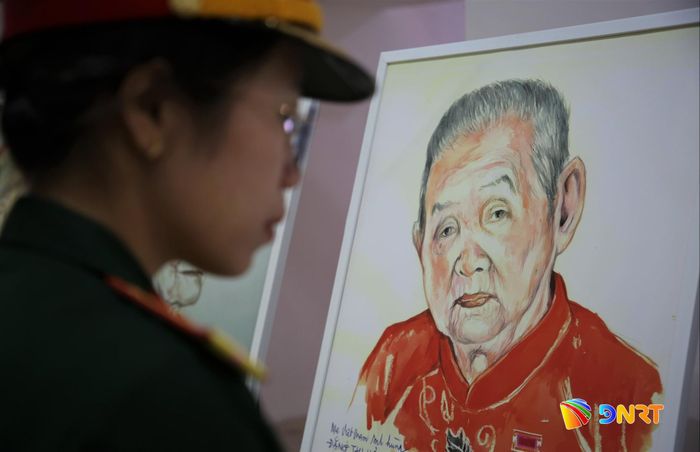 Một chiến sĩ ngắm chân dung Mẹ Việt Nam anh hùng Đặng Thị Hợi (phường Hòa Xuân, thành phố Đà Nẵng) do họa sĩ Đặng Ái Việt vẽ lại. Ảnh: ALĂNG NGƯỚC