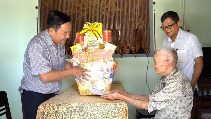 Phó Chủ tịch HĐND thành phố Nguyễn Công Thanh (bên trái) thăm và tặng quà gia đình chính sách tại xã Quế Phước. Ảnh: MINH THÔNG