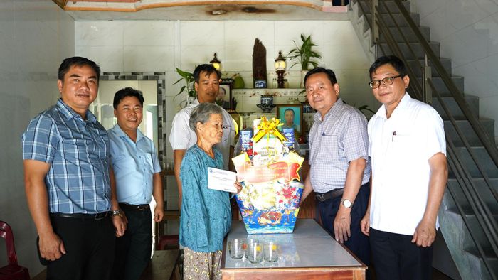Phó Chủ tịch HĐND thành phố Nguyễn Công Thanh (thứ 2, bên phải sang) cùng đoàn công tác thăm, tặng quà gia đình chính sách tại xã Quế Phước. Ảnh: MINH THÔNG