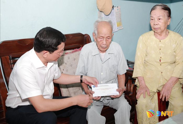 Phó Chủ tịch Thường trực HĐND thành phố Trần Phước Sơn ân cần thăm hỏi sức khỏe thương binh Hồ Cửu. Ảnh: ĐẮC MẠNH