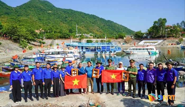 Trao tặng cờ Tổ quốc và tủ thuốc cho ngư dân. Ảnh: ĐVCC