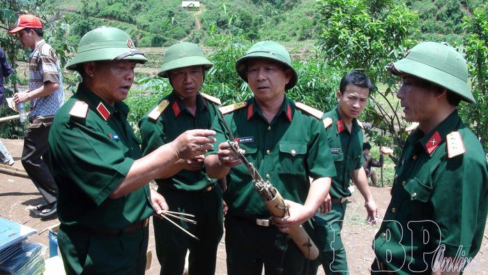 Thiếu tướng Lưu Trọng Lư (ngoài cùng bên trái) cùng lãnh đạo Bộ CHQS tỉnh phân tích đánh giá vũ khí tự chế của các đối tượng. Ảnh tư liệu