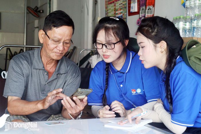 Đoàn viên, thanh niên hỗ trợ người dân sử dụng các tiện ích trên ứng dụng VNeID. Ảnh: Nga Sơn