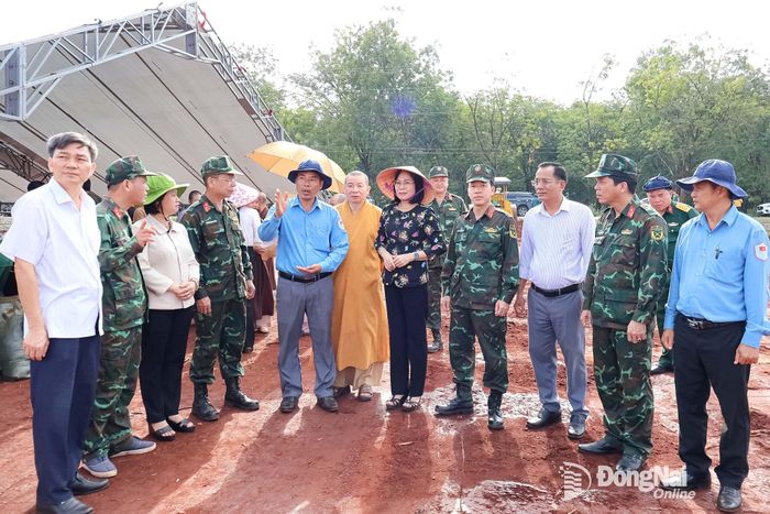 Ban Chỉ đạo thành phố và các đại biểu nghe Thượng tá Vũ Văn Thọ, Đội trưởng Đội K72 giới thiệu một số vị trí lực lượng đang dò tìm nghi có hài cốt liệt sĩ. Ảnh: Nguyệt Hà