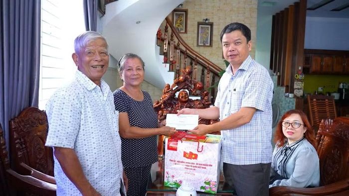 Phó Chủ tịch UBND tỉnh Nguyễn Hữu Quế (thứ 3 từ trái sang) tặng quà cho gia đình thương binh Phạm Thị Sửu (thôn Thịnh Văn 2, xã Vân Canh). Ảnh: Dũng Nhân