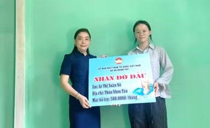 Ban Thường trực Ủy ban MTTQ Việt Nam xã An Nhơn Tây trao bảng tượng trưng nhận đỡ đầu sinh viên Lê Thị Xuân Nở. Ảnh: ĐVCC