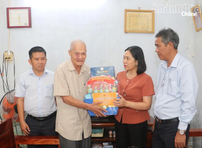 Đồng chí Trần Thu Mai trao quà cho ông Lương Duy Thoại.