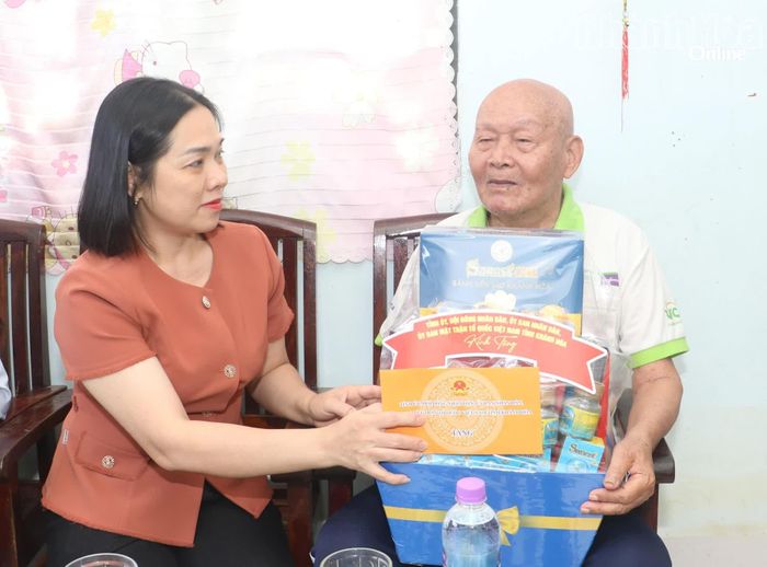 Đồng chí Trần Thu Mai trao quà cho ông Hồ Văn Minh.
