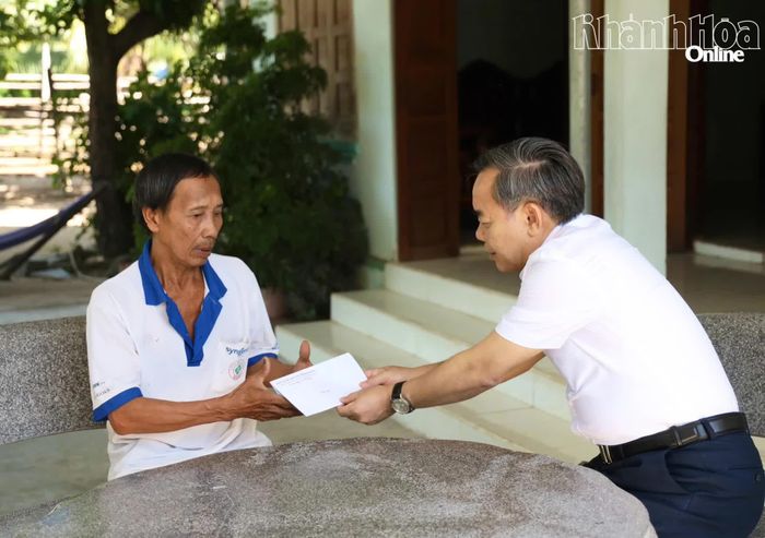 Đồng chí Lê Hữu Trí tặng quà cho gia đình ông Đặng Hòa Nhân. 