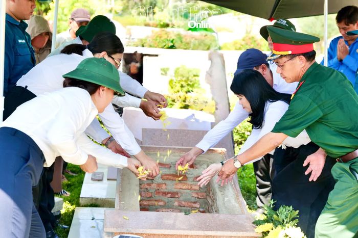 Các đại biểu thả hoa tiễn biệt liệt sĩ Mai Văn Điệu sau lễ an táng.