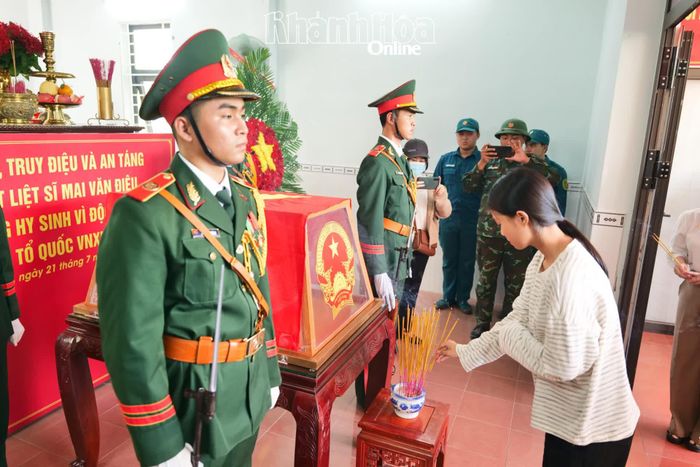 Thân nhân liệt sĩ Mai Văn Điệu dâng hương trong lễ truy điệu và an táng hài cốt liệt sĩ.