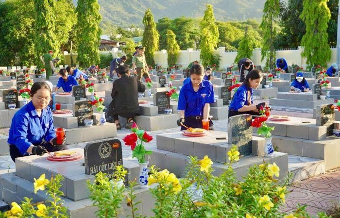 Lực lượng đoàn viên, thanh niên phường Cam Ranh thực hiện sơn sửa mộ liệt sĩ.