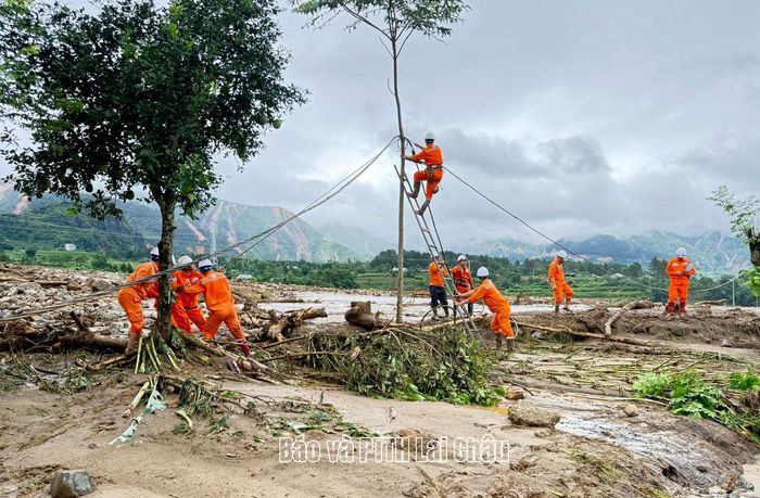 Đội xung kích Công ty Điện lực Lai Châu tập trung kéo dây điện trong vùng lũ.