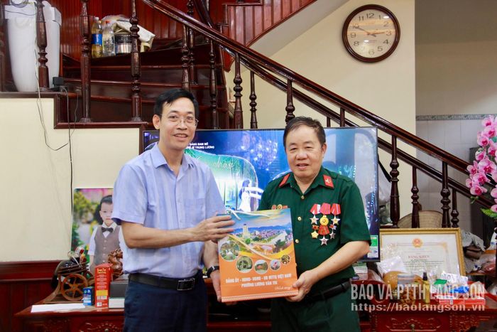 Đồng chí Hoàng Xuân Đồng, Bí thư Đảng ủy, Chủ tịch HĐND phường Lương Văn Tri, trưởng đoàn công tác (bìa trái) tặng quà cho ông Triệu Đình Khánh (khối Cửa Bắc)