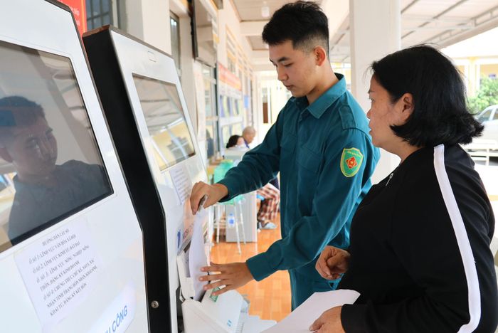 Các chiến sĩ dân quân tự vệ hỗ trợ người dân làm thủ tục hành chính tại Trung tâm Phục vụ hành chính công xã Hiệp Thạnh