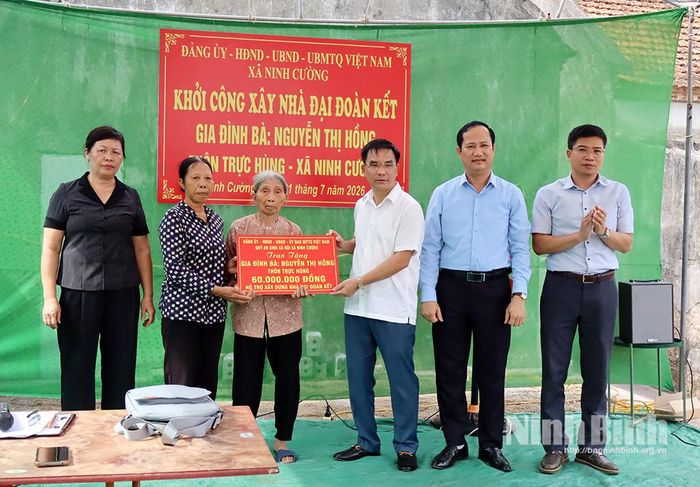 Lãnh đạo Ủy ban MTTQ Việt Nam tỉnh và lãnh đạo xã Ninh Cường trao biển hỗ trợ cho gia đình bà Nguyễn Thị Hồng, ở thôn Trực Hùng.