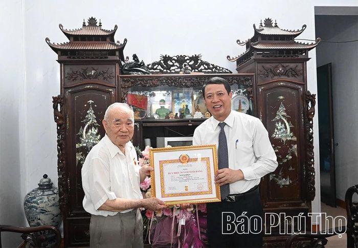 Đồng chí Trưởng Ban Tổ chức Tỉnh ủy Bùi Đình Thi trao Huy hiệu 70 năm tuổi Đảng tặng đảng viên lão thành Ngô Chiến.