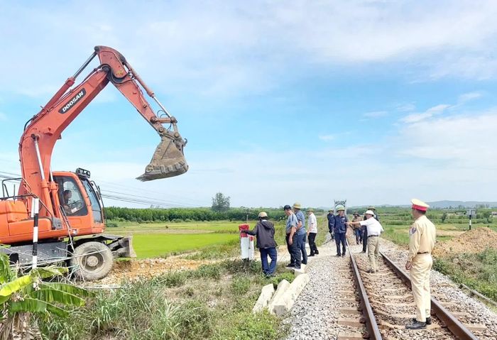 Các lực lượng chức năng tiến hành đóng, xóa bỏ một lối đi tự mở qua đường sắt - Ảnh: B.T