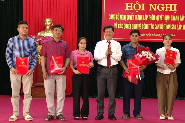 Phó Bí thư Thường trực Đảng ủy xã Quảng Trạch Nguyễn Viết Xuân trao các quyết định về thành lập tổ chức cơ sở đảng và cán bộ thôn sau sắp xếp - Ảnh: B.T