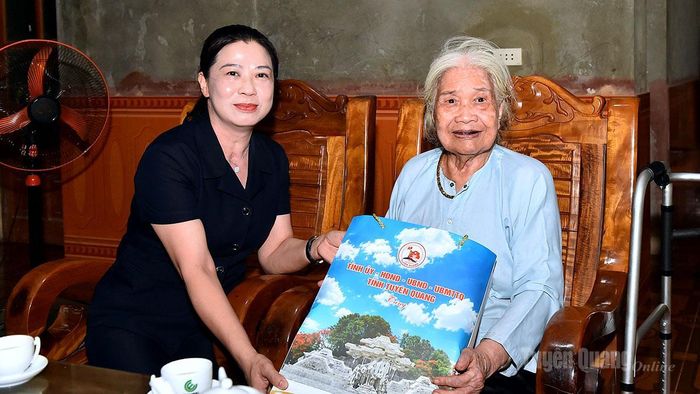 Đồng chí Phó Bí thư Thường trực Tỉnh ủy Lê Thị Kim Dung tặng quà bà Trịnh Thị Chí, thôn Hàm Ếch, là vợ liệt sĩ Hà Văn Lệ.