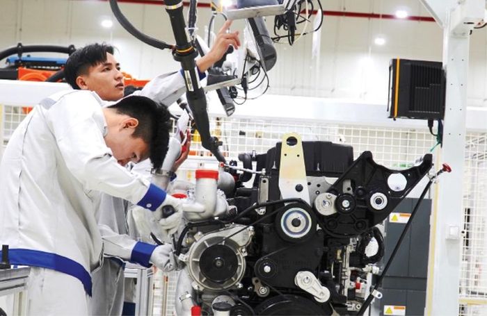 Công nhân Công ty cổ phần Kim Long Motor Huế thực hiện các công đoạn lắp ráp động cơ.