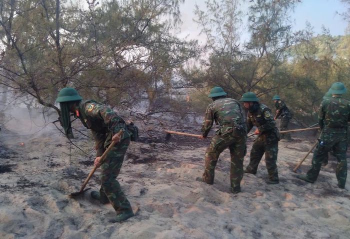 Các cán bộ, chiến sĩ tập trung mở đường băng cản lửa, khoanh vùng đám cháy.