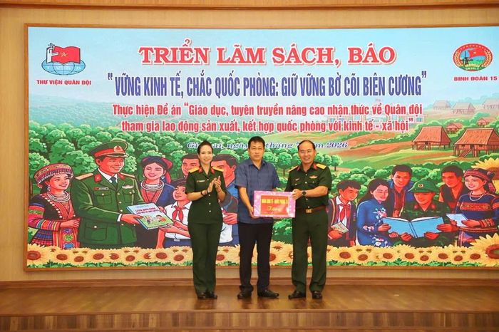 Trung tá Dương Kim Tuấn, Đoàn trưởng Đoàn Kinh tế - Quốc phòng 75 trao quà tặng cho đoàn công tác NXBGDVN.