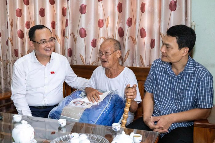 Đại biểu Quốc hội Nguyễn Ngọc Sơn động viên ông Phạm Quốc Việt (sinh năm 1946, ở thôn Tế Bằng) cố gắng vượt qua khó khăn, luôn là tấm gương sáng cho thế hệ trẻ tại địa phương noi theo