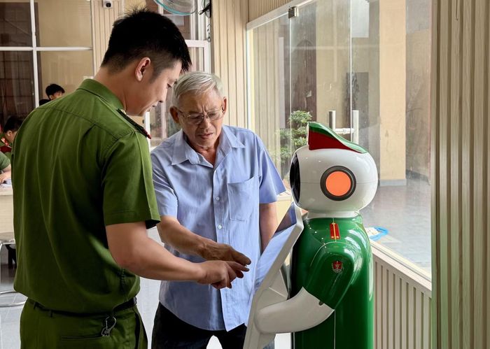 Công an xã Đông Thạnh hướng dẫn người dân thao tác trên Robot lễ tân.