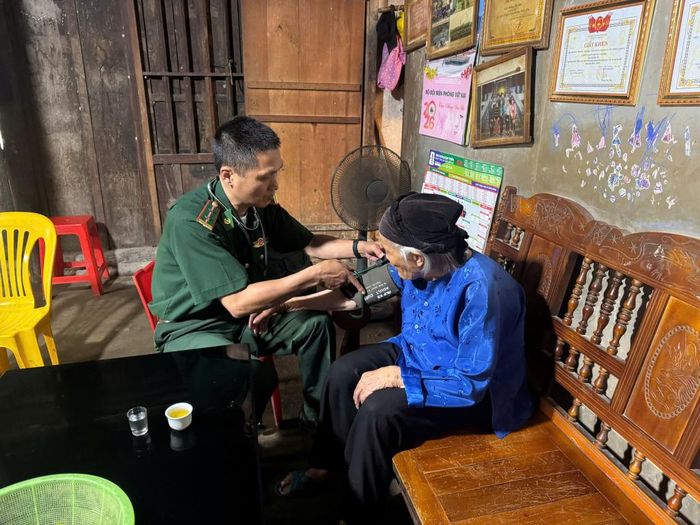 Cán bộ quân y Đồn Biên phòng Tổng Cọt khám bệnh cho mẹ liệt sĩ Nông Thị Sào, SN 1932, trú tại xóm Cọt Phố, xã Tổng Cọt.