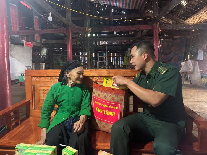 Cán bộ Đồn Biên phòng Tổng Cọt thăm, tặng quà bà Khằm Thị Mẩy là vợ liệt sĩ, trú tại xóm Lũng Ái, xã Tổng Cọt.