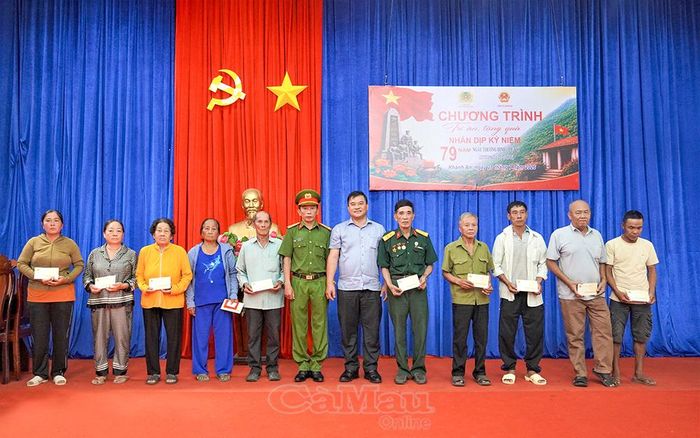 Phó Bí thư Thường trực Đảng ủy xã Khánh An Đặng Hương Giang và Thượng tá Phan Mộng Hải, Phó Giám thị Trại giam Cái Tàu, trao quà cho gia đình chính sách.