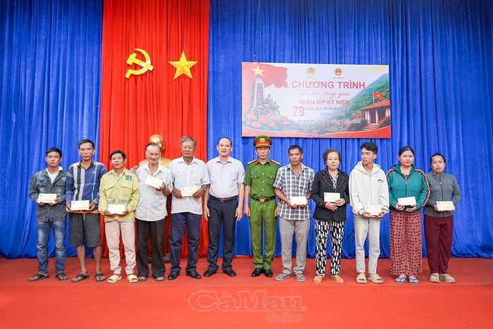 Chủ tịch UBND xã Khánh An Nguyễn Thanh Liêm và Thượng tá Phan Mộng Hải trao quà cho gia đình chính sách.